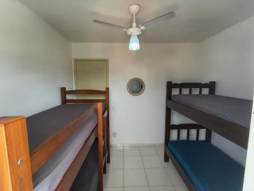 une chambre avec deux lits superposés et un ventilateur de plafond dans l'établissement excelente Cobertura no centro de Bertioga, à Bertioga