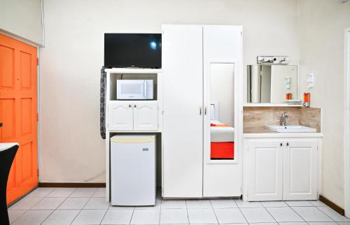 a small kitchen with a white refrigerator and a sink at Melbourne Inn in Christ Church