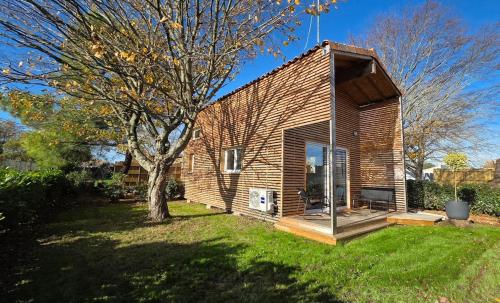 a small house with a tree in a yard at Cottage Atypique in Saint-Laurent-de-la-Prée
