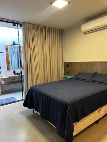 une chambre avec un grand lit et une salle de bain dans l'établissement Casa Astral, à Uberlândia