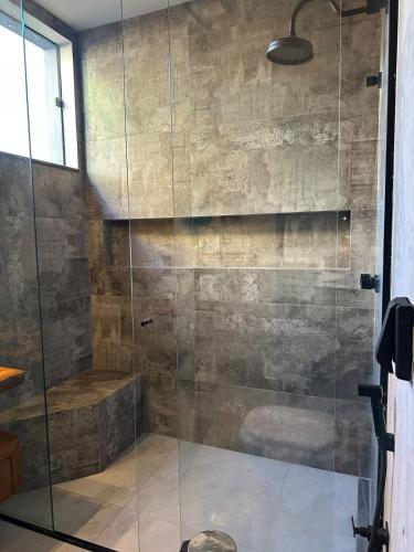 une salle de bain avec une douche avec une porte vitrée dans l'établissement Casa Astral, à Uberlândia