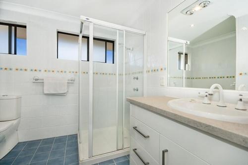 ein weißes Badezimmer mit Dusche und Waschbecken in der Unterkunft Somerset Sunrise Townhouse in Byron Centre in Byron Bay