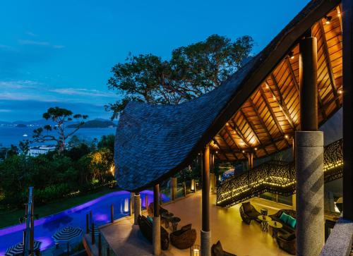 a house with a hammock on the roof at night at Sri Panwa Phuket Luxury Pool Villa Hotel - SHA Plus in Panwa Beach