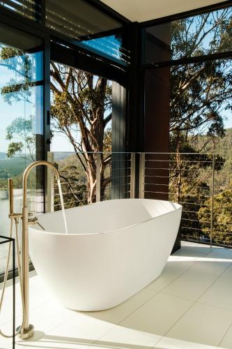 a bath tub in a bathroom with a large window at Mountain Top Snug, House Itas in Snug
