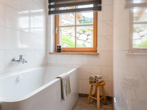 a white bathroom with a tub and a window at Sperlingnest in Donnersbachwald