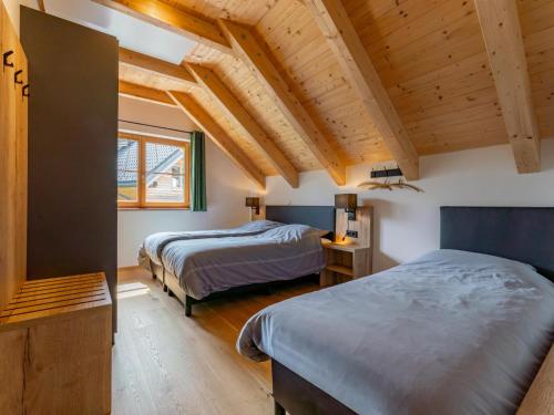 two beds in a room with wooden ceilings at Auerhahn in Donnersbachwald