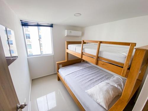 two bunk beds in a small room with a window at Acogedor apto en Coveñas 301 in Coveñas