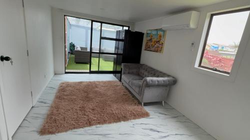 a living room with a couch and a rug at 2bed granny flat close to Auckland Airport in Auckland
