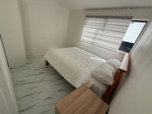 um pequeno quarto com uma cama e uma janela em 2bed granny flat close to Auckland Airport em Auckland