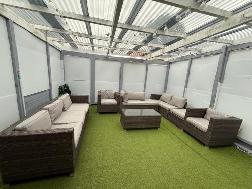 a large room with couches and tables and windows at 2bed granny flat close to Auckland Airport in Auckland