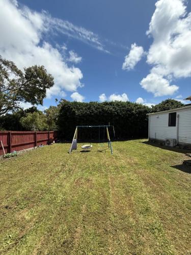 a swing set in the middle of a yard at 2bed granny flat close to Auckland Airport in Auckland