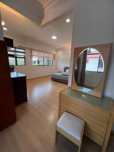 Zimmer mit einer Kommode mit einem Spiegel und einem Bett in der Unterkunft B&C Homestay in Miri