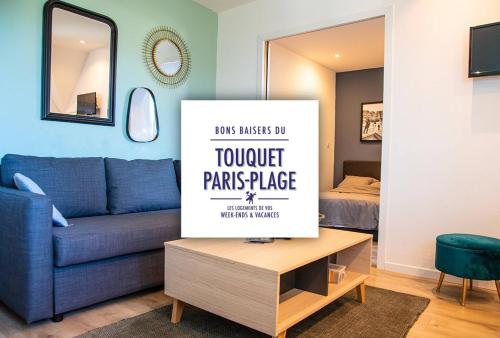 een woonkamer met een blauwe bank en een tafel bij Résidence grand jardin attenant tennis, mini golf, sauna, pétanque in Stella-Plage