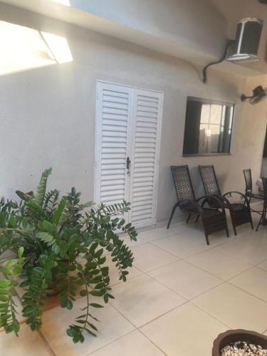 ein Zimmer mit Stühlen, Pflanzen und einer Tür in der Unterkunft Casa espaçosa e confortável perto do Aeroporto in Sao Jose do Rio Preto