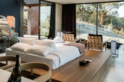 une chambre avec un grand lit et une table et des chaises dans l'établissement Mountain Top Snug, Studio Itas, à Snug