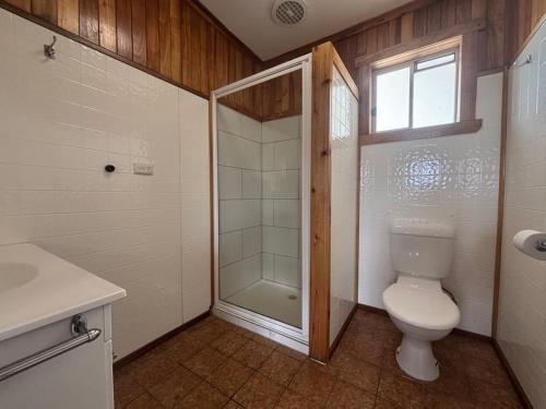 e bagno con servizi igienici, doccia e finestra. di White Sands – Coastal Comfort Made Easy a Four Mile Creek