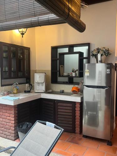 Qiyis Cottage في جورج تاون: مطبخ مع ثلاجة ستيل ستانلس ومرآة