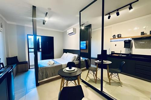 ein Hotelzimmer mit Bett und Küche in der Unterkunft Loft 306 - Praticidade e estilo na esquina da Ufu in Uberlândia