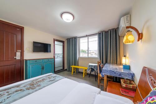 a hotel room with a bed and a desk and a tv at Junshe Boutique Guest House-Complementary pick up servie for a 3-night stay in a deluxe room in Guilin