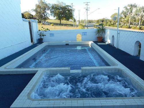 una pequeña piscina de agua en un patio trasero en Siesta Villa Motel en Gladstone