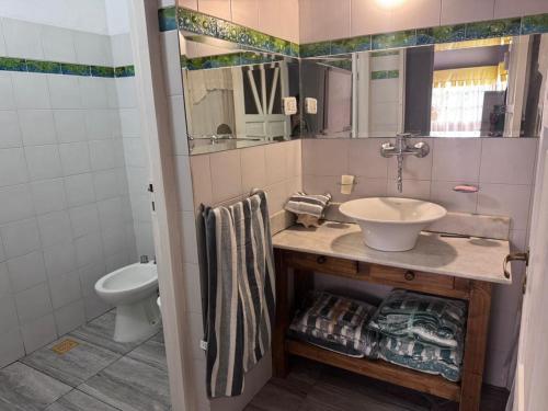 une salle de bain avec un lavabo et des toilettes dans l'établissement "Kalula" Casa de Campo en Raco, à Siambón