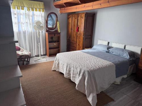 - une chambre avec un lit, une commode et un ventilateur dans l'établissement "Kalula" Casa de Campo en Raco, à Siambón