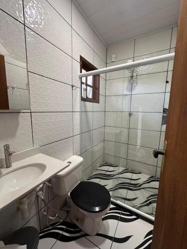 a bathroom with a toilet and a sink at Casa Sol & Mar in Arraial do Cabo