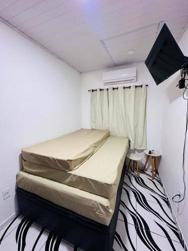 a small bedroom with two beds and a window at Casa Sol & Mar in Arraial do Cabo