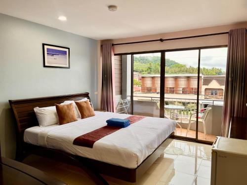 um quarto com uma cama e vista para uma varanda em Mookanda Residence em Praia de Ao Nang