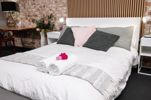 a bedroom with a white bed with two towels on it at Mirambeena Retreat in Toowoomba