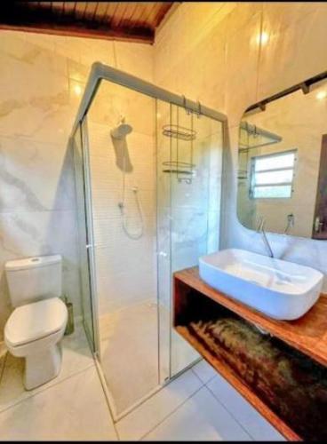 a bathroom with a toilet and a sink and a shower at Pousada Encantos do Rosa in Imbituba