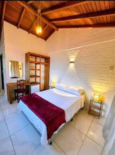 a bedroom with a large bed in a room at Pousada Encantos do Rosa in Imbituba
