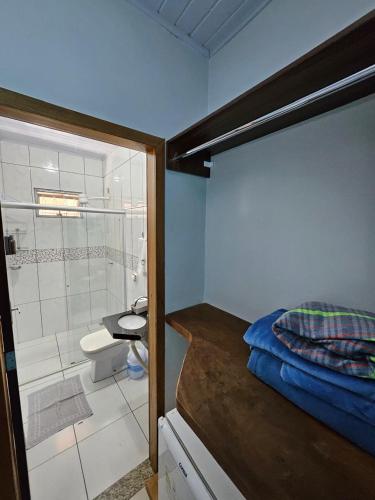 a small bathroom with a bed and a shower at Pousada Bom Jardim in Estivado