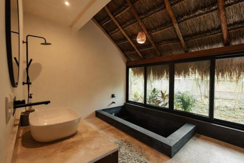 a bathroom with a tub and a large window at Your Refuge in the Mayan Jungle Cobá, 2 Bedrooms in Cobá