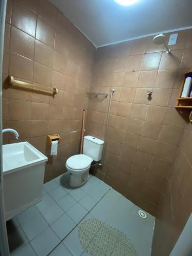 een kleine badkamer met toilet en douche bij Flat há 15 min da Pajuçara in Maceió