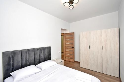 ein Schlafzimmer mit einem großen Bett mit schwarzem Kopfteil in der Unterkunft Transit HoteL in Geghanist