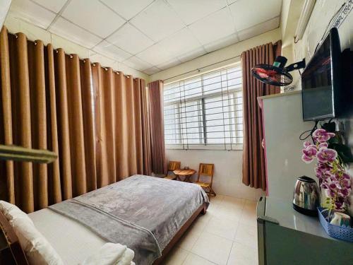 a small bedroom with a bed and a television at Ren Apartments in Ho Chi Minh City