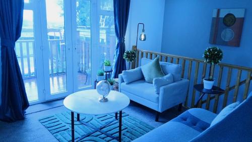 a living room with a couch and a table at Shetcliffe Lodge in Dudley Hill