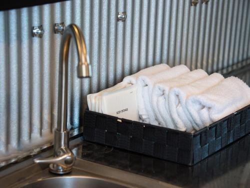 ein Korb mit Handtüchern auf einer Theke neben einem Waschbecken in der Unterkunft Rockstar Villa 江井浜STYLE in Awaji