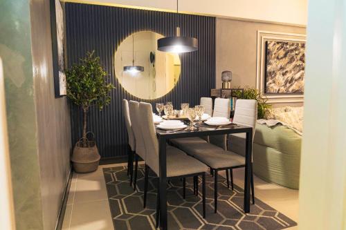 una sala da pranzo con tavolo, sedie e specchio di Casa Celestine Staycation a Manila