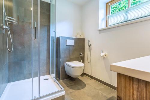 a bathroom with a toilet and a glass shower at Active Chalet in Maria Alm am Steinernen Meer