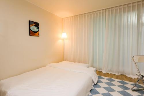 Una cama o camas en una habitación de 1'Near Hongdae Station, 30sec on foot