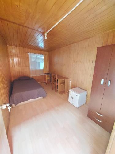 康塞普西翁Habitación individual para hombres `的一间带床和书桌的小卧室