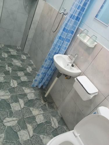a bathroom with a toilet and a sink at Castello in Tomohon