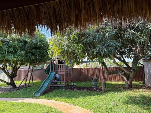 Un parque infantil con un tobogán en un patio en Peace and Tranquility awaits, en Miami Gardens