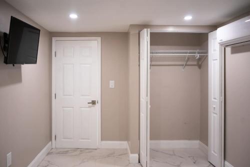 vestidor con puerta blanca y TV en Peace and Tranquility awaits, en Miami Gardens
