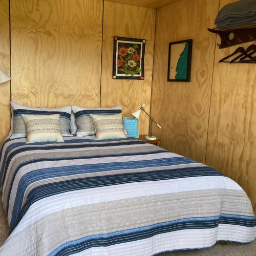 a bedroom with a large bed with blue and white sheets at Seascape on Maude in Oamaru