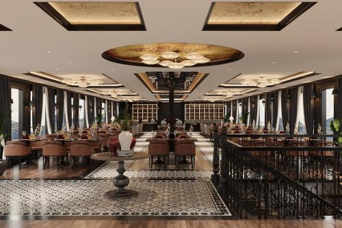 een restaurant met tafels en stoelen en een groot plafond bij AIME'E CRUISES - Halong Bay in Ha Long