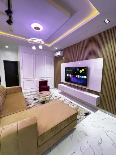 ein Wohnzimmer mit Sofa und Fernseher in der Unterkunft Luxurious 2bedroom Apartment PS5 in Ibadan