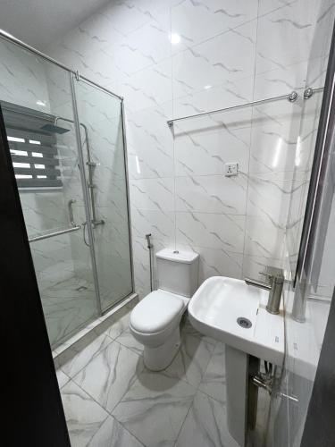a bathroom with a toilet and a shower and a sink at Luxurious 2bedroom Apartment PS5 in Ibadan